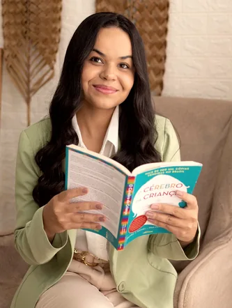 Mayara Fernanda lendo o livro O Cérebro da Criança em poltrona aconchegante, em Cascavel